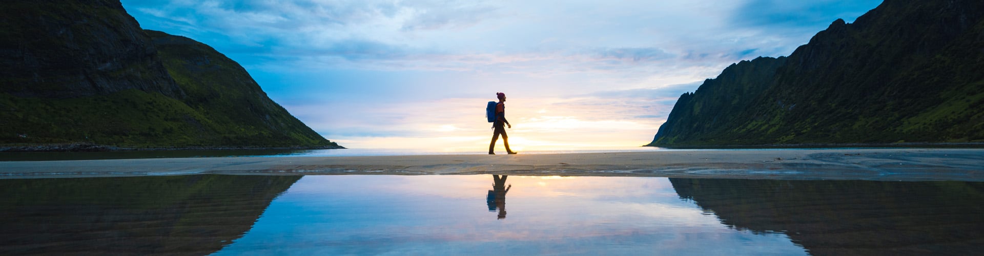 Man walking on a beach during sunset