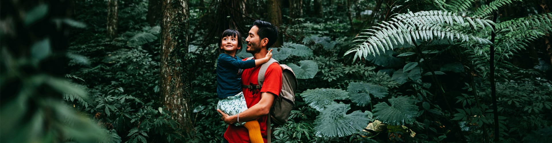 Man holding child in rainforest